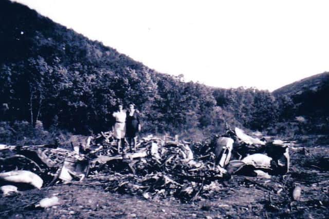 Two locals with the area covered by debris from the crash
