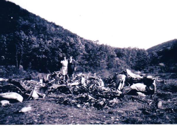 Two locals with the area covered by debris from the crash
