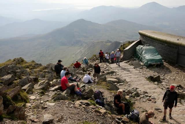 Walkers at the summit of Mount Snowdon in Snowdonia, Wales.