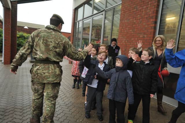 Pupils on the way to their temporary school in Army training facilities