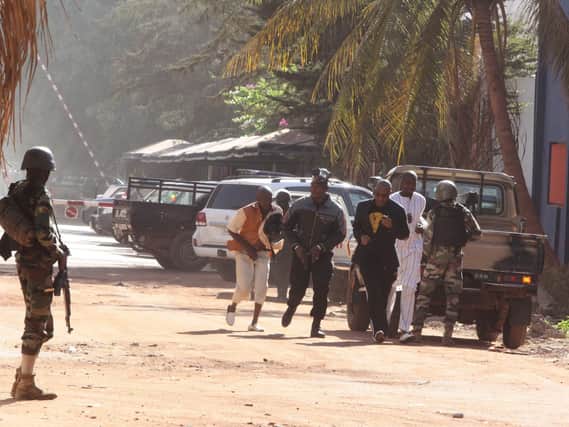 People run to flee from the Radisson Blu Hotel in Bamako, Mali