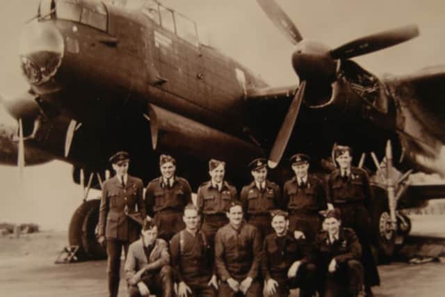 Flight Lieutenant Austin Hallett, second from the right on the back row, in front of a Lancaster bomber