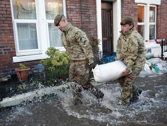 Members of the armed forces help distribute sandbags to residents following flooding in Carlisle. Photo: Owen Humphreys/PA Wire
