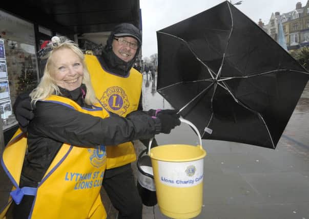 Lytham St Annes Lions members Eileen Skelly and Axel Cowalsky collecting money for Cumbria in a rainy St Annes