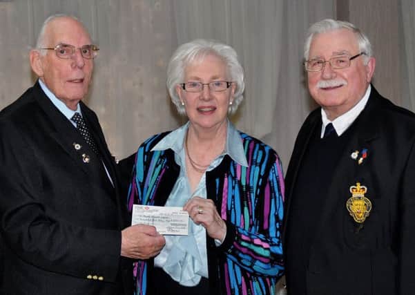 Anne Halsall of  Lytham Soroptimists International of the Fylde presents a cheque for £1055.00 to Lytham and St Annes Poppy Appeal organiser Spencer Leader (left) and assistant Poppy organiser, Albert Cooper.