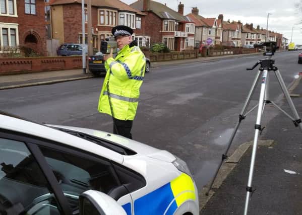 Special Sgt Richard Cardwell aims a speed camera at oncoming motorists