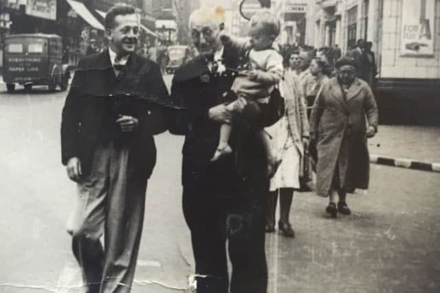 Roland Barnes in his father's arms with granddad alongside. Mam and grandma are just behind. This was snapped beside The Olympia Pleasure Palace, Blackpool