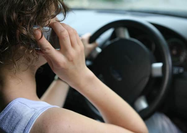 A woman using her mobile phone while driving.