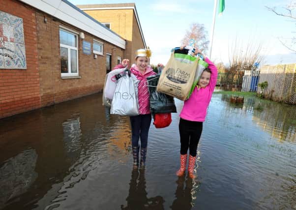 Martha and Abbie Cornthwaite rescue their nativity costumes from St Michaels on Wyre CE Primary School after Storm Desmond caused flooding in the area