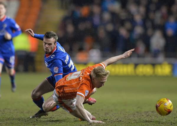 Blackpool's Mark Cullen is tackled by Oldham Athletic's Cameron Dummigan