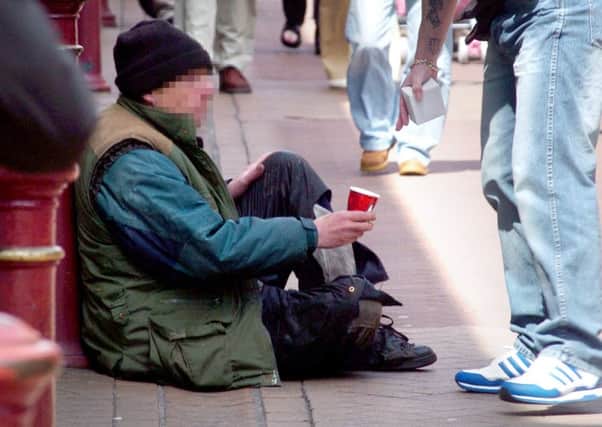 A homeless man in Blackpool is given some change by a passing member of the public.