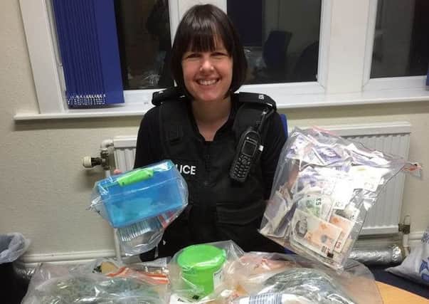 PC Paula Robertson with cash and suspected drugs found in a Blackpool home