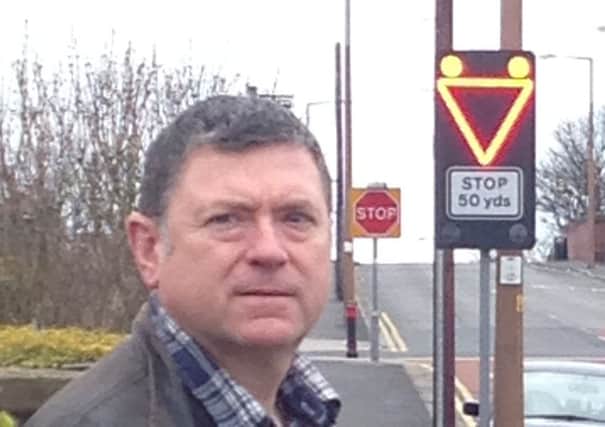 County Coun Peter Buckley at the new flashing stop sign at the junction of St Leonard's Road East with St David's Road North, St Annes