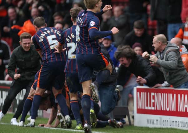Blackpool fans mob the players after Tom Aldred scored the winning goal at Crewe