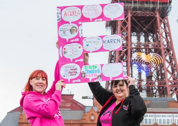 Wendy Barratt (left), of WHF Studios, with friend and colleague Karen Wrigley, holding up the letter E in front of Blackpool Tower Race for Life Blackpool