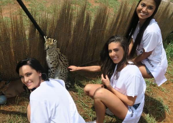 Joanna Johnson (centre), with Louise (left), representing Africa and (right) Hazel, from the Phillippines at a cheetah park, visiting the cheetahs and wild cats