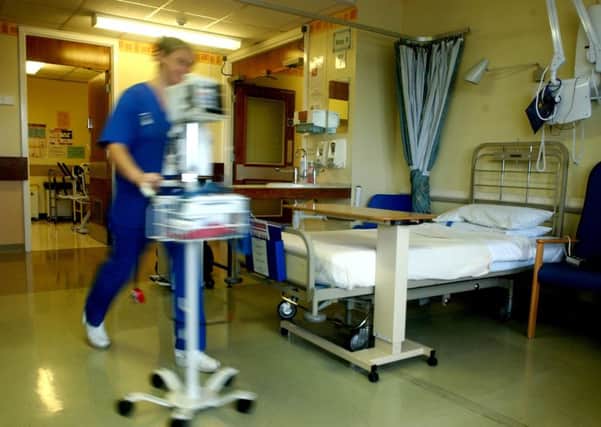 A nurse rushes past the only empty bed in Royal Preston Hospital - ward