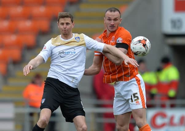 Blackpool's Tom Aldred battles with Colchester United's Chris Porter