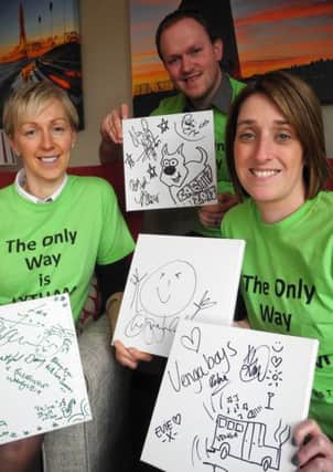 Trinity Hospice fundraisers Rebecca Greaves (left), Matt Porter and Linzi Young with doodles from Lytham Festival 2015 up for auction