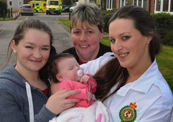 Sarah Unsworth, a 999 call handler, right, meets baby Lexi, now eight-weeks-old, after she helped Joanne Pickles, centre, deliver her own grandchild as Hayley Thompson, left, went into labour, pictured at North West Ambulance Service headquatures in Broughton,