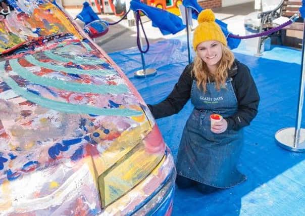 Helen Taylor, owner of Fleetwood art company Glazey Days, with the decorated car at Freeport, which raised funds fro Brian House