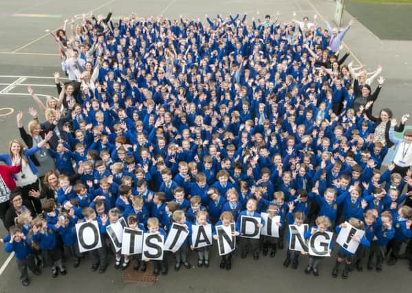 Staff and pupils from St Nicholas Primary School celebrate after being rated outstanding by Ofsted
