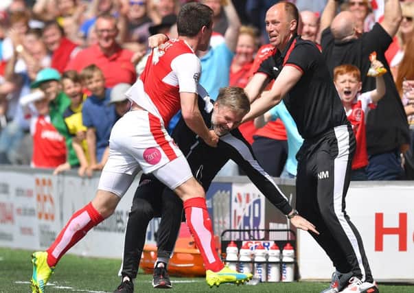Fleetwood Town's Bobby Grant celebrates scoring his team's opening goal by knocking over Manager Steven Pressley