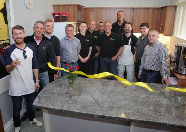 Trades from across Blackpool worked together free of charge to build a new kitchen for the Amazing Graze homeless charity on Boothley Road.
Local boxing star Scott Cardle cuts the ribbon to officially open the kitchen, watched by the tradesmen who built it.  PIC BY ROB LOCK
13-5-2016