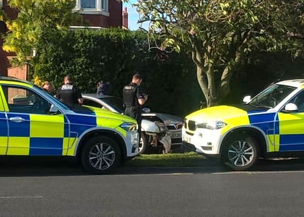 Police search a Vauxhall Vectra which crashed on Preston New Road