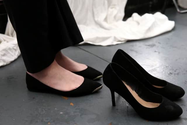 Nicola Thorp wearing the flats which caused her to be sent home from her job at PriceWaterhouseCoopers. Also pictured is a pair of high heels which the company required that she wear instead. See SWNS story SWHEELS: A temp worker who was sent home from a top City accountancy firm for not wearing high heels has set up a petition to make it illegal. Actress Nicola Thorp claims she was sent home from a receptionist job at PriceWaterhouseCoopers without pay after she turned up with flat shoes on. She claims she was told it would be "ridiculous" for men to wear heels, but that it was "female grooming policy" for women to wear two to four inch heels. Since she started the petition she has gained over 5,000 signatures and aims to reach 100,000 whereby the petition will be considered for a debate in parliament.