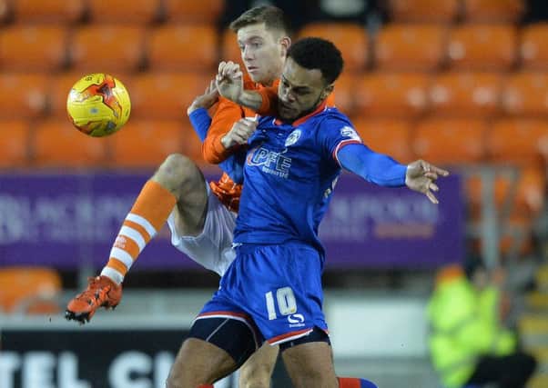 Blackpool's Clark Robertson battles with Oldham Athletic's Aaron Holloway