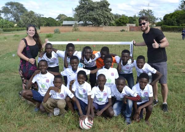 AFC Fylde fans Kirsty Aksoy and Roger Smith with youngsters sporting the clubs shirts in Zambia