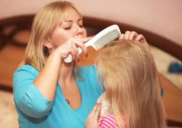A mother checking her daughter's hair for head lice.