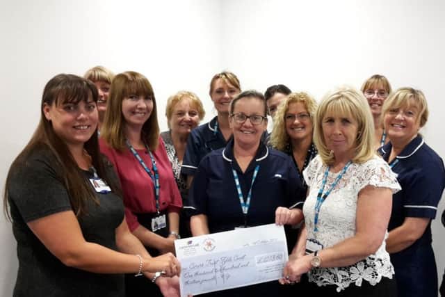 Julie Swift (left) carers charity administrator receives cheque from Lorraine Tymon and rest of team