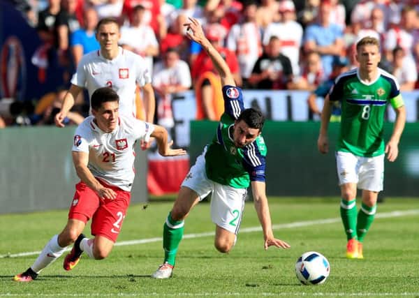 Poland's Bartosz Kapustka (left) and Northern Ireland's Conor McLaughlin battle for the ball during the UEFA Euro 2016, Group C match at the Stade de Nice, Nice. PRESS ASSOCIATION Photo. Picture date: Sunday June 12, 2016. See PA story SOCCER N Ireland. Photo credit should read: Jonathan Brady/PA Wire. RESTRICTIONS: Use subject to restrictions. Editorial use only. Book and magazine sales permitted providing not solely devoted to any one team/player/match. No commercial use. Call +44 (0)1158 447447 for further information.