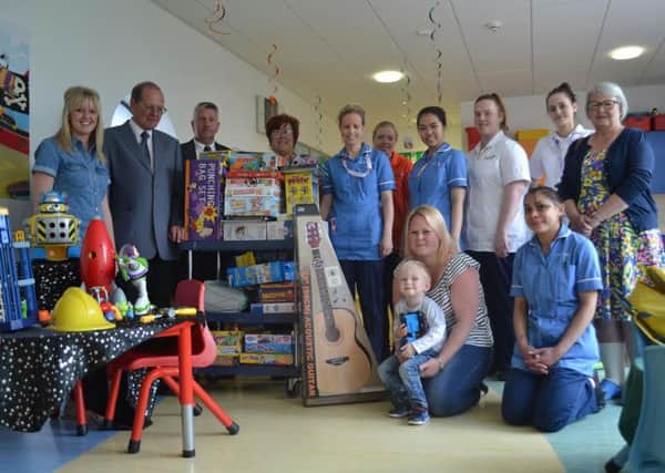 Louise Hall and Daniel, two, visit staff on the childrens ward where they have donated toys with family members Rachel and Nigel Hind and Andrew Cross, far left, and Kate Hind, far right.