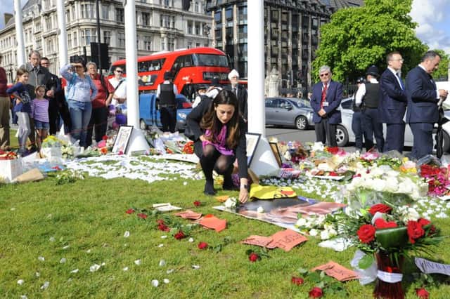 A woman lays flowers at a memorial on Parliament Square after a service at St Margaret's church, London. PRESS ASSOCIATION Photo. Picture date: Monday June 20, 2016. See PA story POLITICS MP Service. Photo credit should read: Lauren Hurley/PA Wire