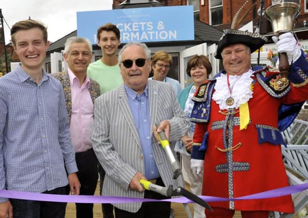 Bobby Ball cuts the ribbon on the Festival ticket office, watched by town crier Colin Ballard (right) and guests including designer Greg Anderton (left) and Fylde Council chief executive Allan Oldfield
