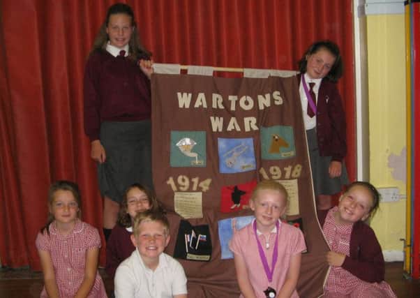 Members of St Paul's School sewing club with a First World War banner they have made for the Warton Village Somme commemoration