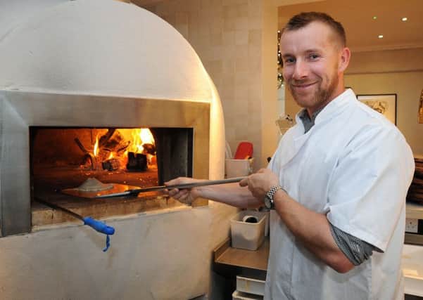 Lancashire cricket star Stephen Croft joined the Gazette's Anna Cryer at Gusto restaurant in Lytham to create one of the restaurant's favourite dishes. 
Stephen slides the pizza base into the wood-fired oven.