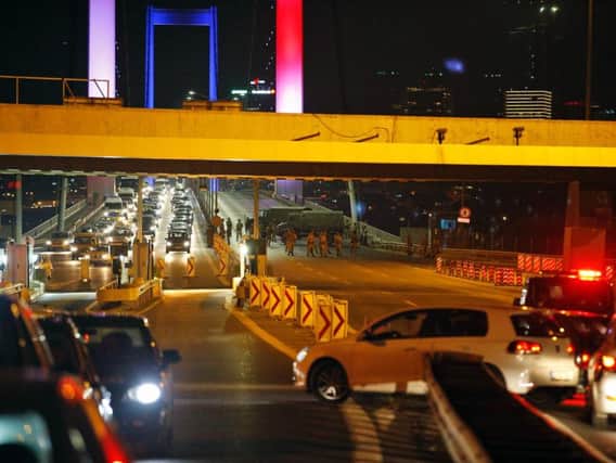 Turkish soldiers block Istanbul's iconic Bosporus Bridge, lit in the colours of the French flag in solidarity with the victims of Thursday's attack in Nice, France.