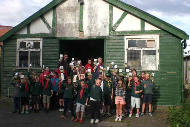 The 8th Lytham St. Annes Cubs holding up the Scout Hut Appeal leaflet which is going to every household in Lytham