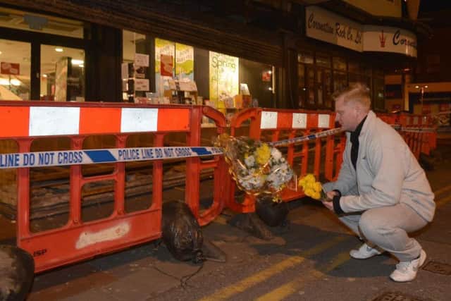 Mark English, store detective at B&M Bargains on Bank Hey Street, lays flowers for Margaret Sheridan, who died when a shop sign fell on her. Mr English tried to save her but her injuries were too severe.