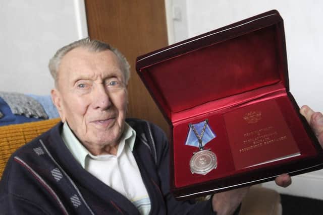 WW2 veteran Peter Kyle is awarded a Ushakov Medal by attaché of the Russian embassy Oleg Shor for his war effort in the Arctic convoys.