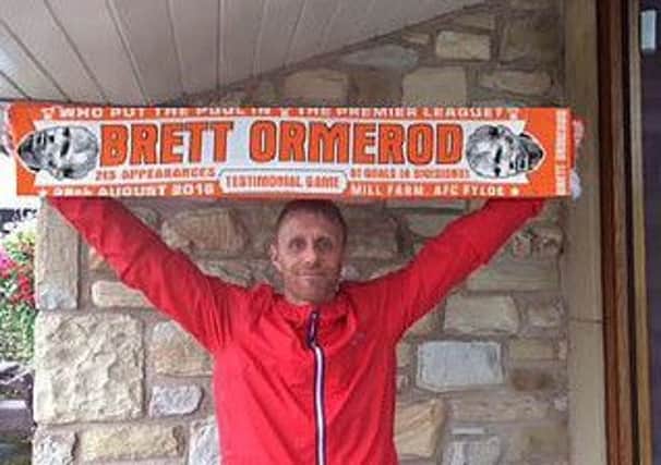 Brett Ormerod holds a souvenir scarf