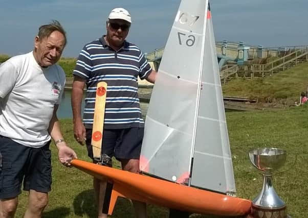 John Brooks (left) and Derek Priestley, of Fleetwood Model Yacht and Power Boat Club,  with their winning yacht and cup after success at Gosport, Hampshire.