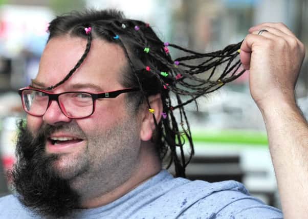 Photo: David Hurst Gavin Howard has his plaits and beard cut and shaved in small parts by passers by on Friargate in aid of Macmillan Cancer