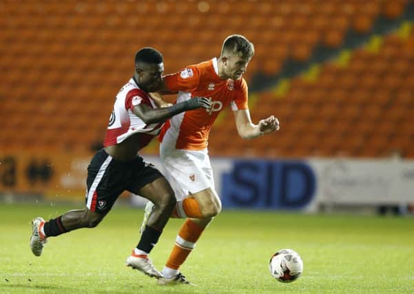 Blackpool's Will Aimson competes with Cheltenham Town's Koby Arthur