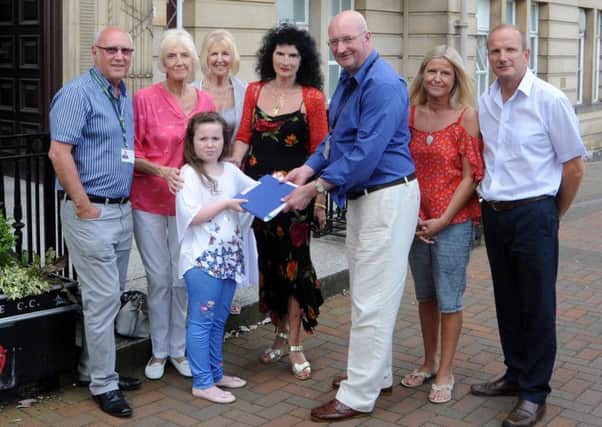 Nine-year-old Cara Restrick presents a petition of more than 4,000 names objecting to proposals to close Lytham Library to County Coun Marcus Johnstone, watched by (from left) Fylde councillor Ray Thomas, Kate Patton, Anne McGettigan, Vivien Idell, Louise Payton and Fylde and Lancashire County councillor Tim Ashton