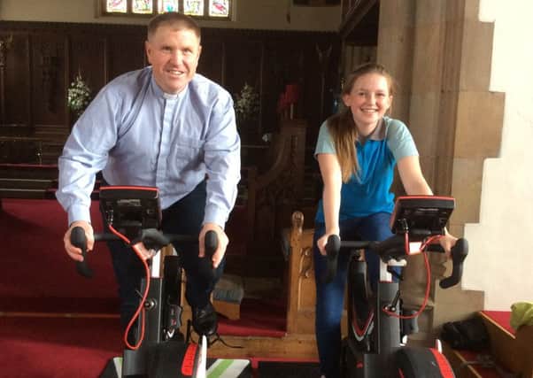 Charlotte Rossall, 14, and Rev Rick Bunday, vicar of St Michael's Kirkham, on fixed bikes in church to raise funds for Malawi ahead of Charlotte's trip there in 2017.